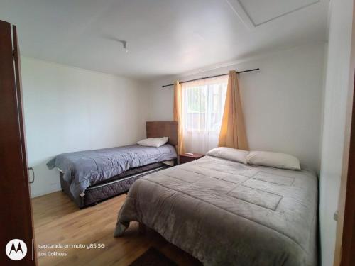 a bedroom with two beds and a window at Agroturismo los Colihues 2 in Castro