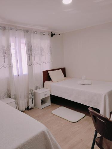 a bedroom with two beds and a window at Hotel Victoria in Iquique