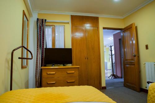 a bedroom with a bed and a television on a dresser at Hotel Cima Argentum in Potosí
