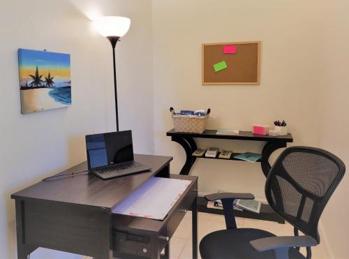 an office with a desk with a laptop and a chair at Long Bay View Villa in Leeward