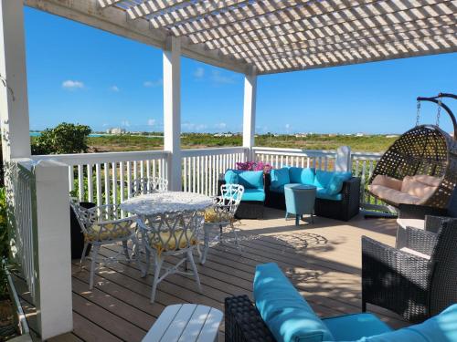 a patio with a table and chairs on a deck at Long Bay View Villa in Leeward