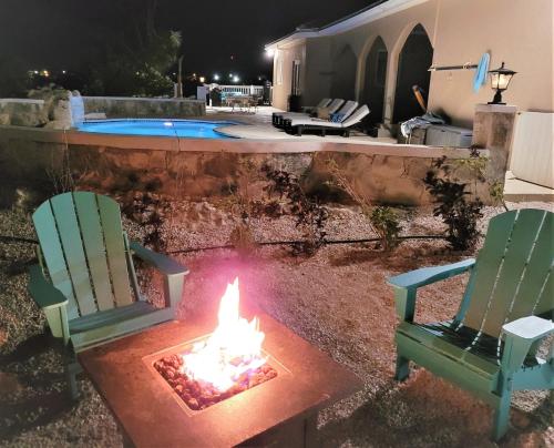 two chairs and a fire pit in a yard at Long Bay View Villa in Leeward