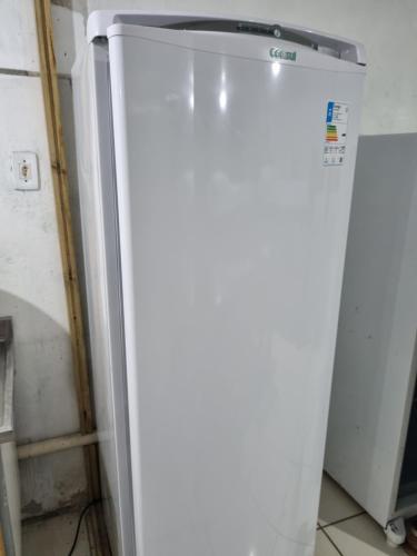 a refrigerator freezer sitting in a kitchen next to a wall at Oca do Ric in Imbituba