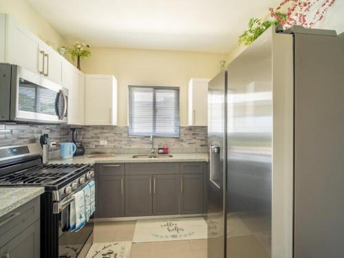 a kitchen with a stainless steel refrigerator and a stove at Seashell Villas in Lucea