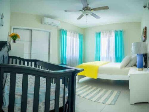 a living room with a bed and a ceiling fan at Seashell Villas in Lucea