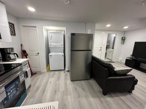 a kitchen with a refrigerator and a couch in it at Muaysh Cozy Family suite - Londonderry Mall in Edmonton