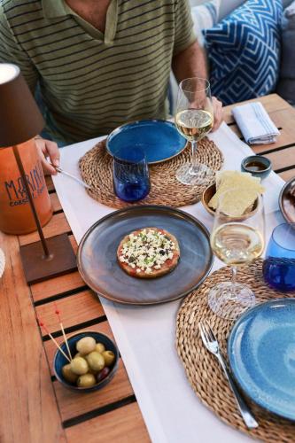 a table with a pizza and glasses of wine at Hotel Arts Barcelona in Barcelona