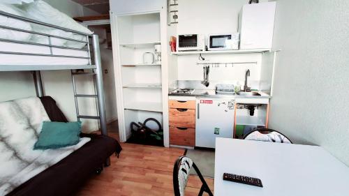 Cette petite chambre comprend des lits superposés et une cuisine. dans l'établissement Petit nid au Pic du Midi, à Bagnères-de-Bigorre