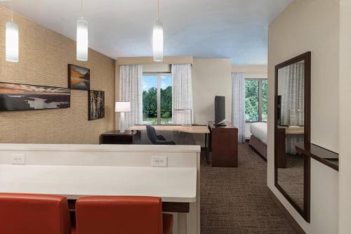 a hotel room with a desk and a living room at Residence Inn By Marriott Greenville in Greenville