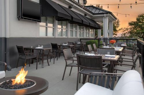 an outdoor patio with tables and chairs and a fire pit at Holiday Inn Hotel & Suites Overland Park-West by IHG in Overland Park