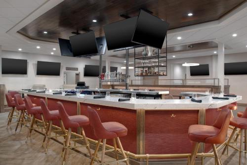 a bar with a row of stools in a room at Holiday Inn Hotel & Suites Overland Park-West by IHG in Overland Park