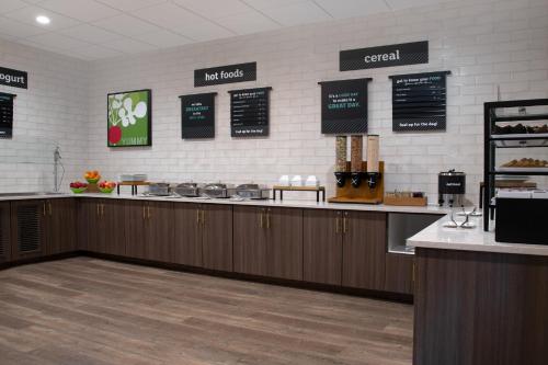 a restaurant with a counter and aasteryasteryasteryasteryasteryasteryasteryasteryastery at Holiday Inn Hotel & Suites Overland Park-West by IHG in Overland Park