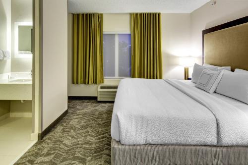a hotel room with a bed and a sink at SpringHill Suites Port Saint Lucie in Port Saint Lucie