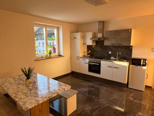 a kitchen with white appliances and a table in it at Apartment Krasniqi in Hönigsberg