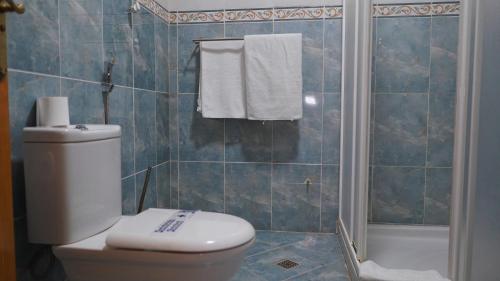 a bathroom with a toilet and a shower with towels at Hôtel Prestige in Nouadhibou