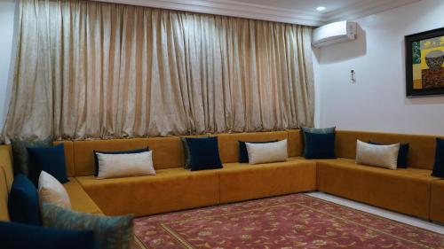 a couch with pillows sitting in a living room at Hôtel Prestige in Nouadhibou