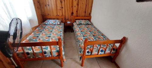 two twin beds in a room with a wall at Günay - Barra del Chuy in Barra del Chuy