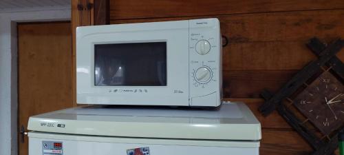 a microwave sitting on top of a refrigerator at Günay - Barra del Chuy in Barra del Chuy