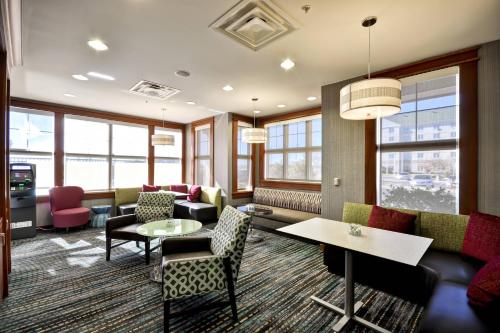 a living room with a couch and tables and chairs at Residence Inn by Marriott Gulfport-Biloxi Airport in Gulfport