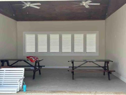 a room with two picnic tables and a window at VillaMerissa Ocenpointe in Point