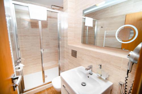 a bathroom with a sink and a shower and a mirror at Spirit Harrachov Superior Wellness Apartment - FREE Wellness, Wifi, Parking in Harrachov