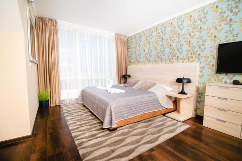 a bedroom with a bed and a flat screen tv at Spirit Harrachov Superior Wellness Apartment - FREE Wellness, Wifi, Parking in Harrachov