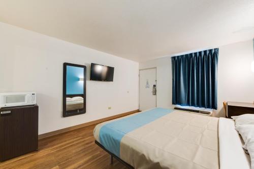 a hotel room with a bed and a tv at Motel 6-Kingston, TN in Kingston