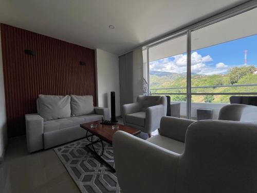 a living room with couches and a large window at Luxury Apartment Citadela de Sole Santa fe de Antioquia in Santa Fe de Antioquia