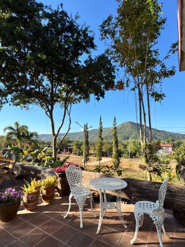 einen Tisch und Stühle auf einer Terrasse mit Aussicht in der Unterkunft Green Hill Resort Phurue in Phu Rua