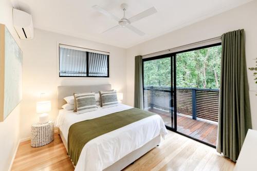 a bedroom with a bed and a large window at The Sunshine Beach Luxe Coastal Retreat in Sunshine Beach