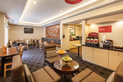 a hotel lobby with couches and a dining room at TownePlace Suites Jacksonville Butler Boulevard in Jacksonville
