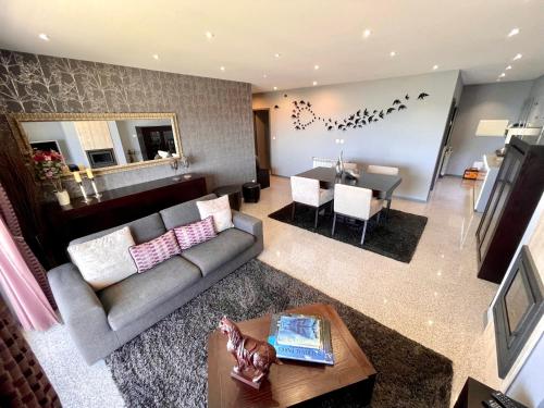a living room with a couch and a dining room at Condominio encantador, com piscina e vista mar - Ocean View Apartment in Viana do Castelo