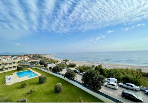 a view of a beach and a parking lot with cars at Condominio encantador, com piscina e vista mar - Ocean View Apartment in Viana do Castelo