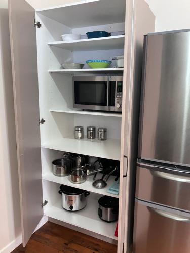 a kitchen with a microwave and a refrigerator at City oasis in Gisborne