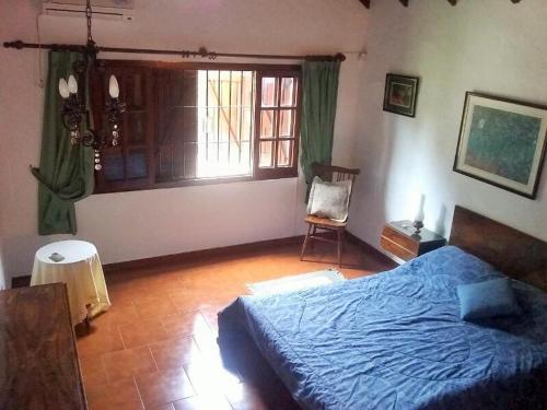 a bedroom with a blue bed and a window at Duplex a 500m de la playa in Villa Gesell