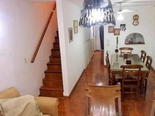 a living room with a dining room table and a staircase at Duplex a 500m de la playa in Villa Gesell
