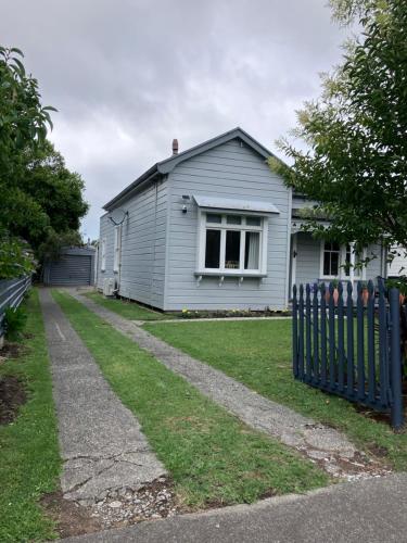 a white house with a fence in front of it at City oasis in Gisborne