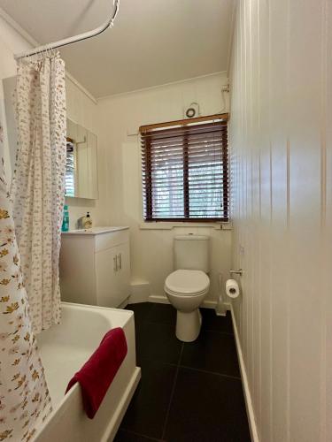Un baño con inodoro, bañera y lavabo. en Nestled on Tower Hill's edge, with stunning views!, en Koroit