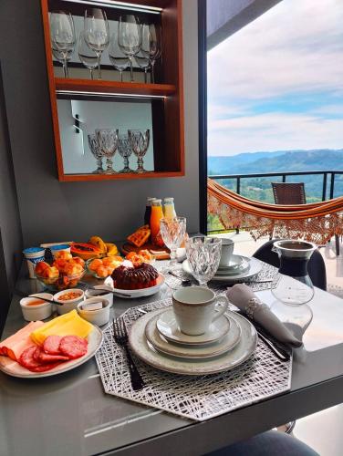 Sombra na Montanha في نوفا بتروبوليس: طاولة مع أطباق من الطعام على طاولة مطلة