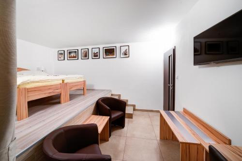 a room with a bed and a desk and chairs at Penzion Královská Cesta in Brno