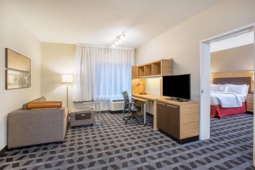 a hotel room with a bed and a desk with a television at TownePlace Suites by Marriott Olympia in Olympia