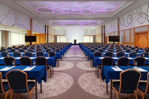 a large room with blue tables and chairs at The Westin Leipzig in Leipzig