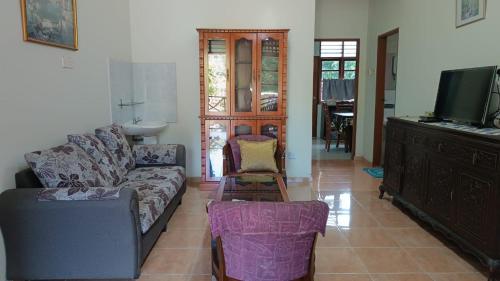 a living room with a couch and a tv at KaLong Bay Homestay Villa Seroja in Kampong Telok Kalong