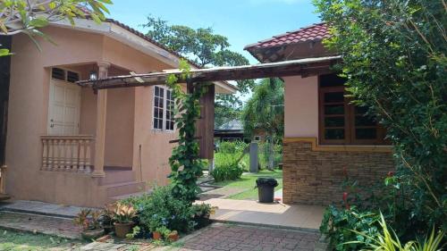 a small house with a wooden pergola at KaLong Bay Homestay Villa Seroja in Kampong Telok Kalong