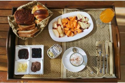 a tray of food with plates of food and fruit at Excellent Desert Safari camp in Sām