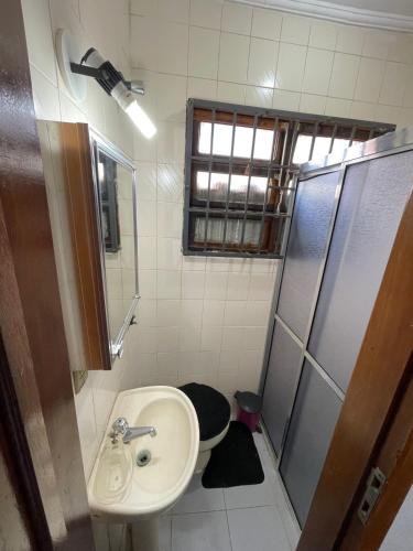 a small bathroom with a sink and a shower at Recanto Casa de Pedrinha - Aptos para temporada e finais de semana in Caraguatatuba