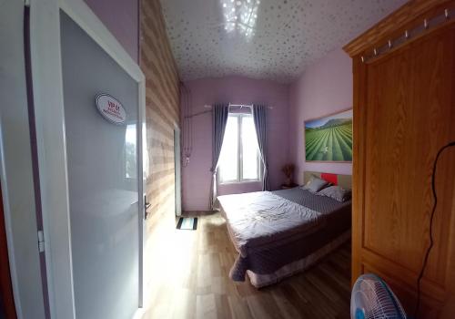a small bedroom with a bed and a window at Nông Trại Về Cội - The Original Farm in Buôn Bedeur