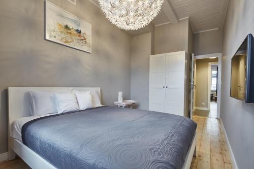 a bedroom with a large bed and a chandelier at PlayRoom II Apartment in Krakow