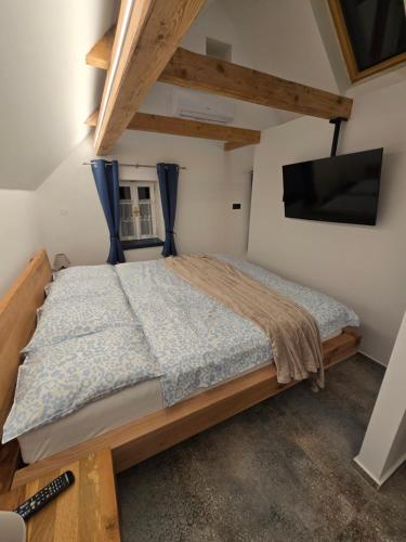 a bedroom with a bed and a flat screen tv at Podkrovní stylový mezonetový apartmán in Kunratice