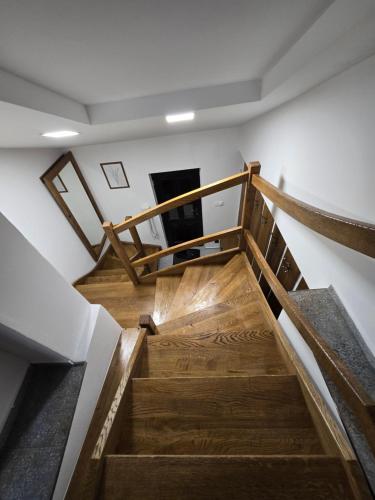 a winding staircase in a building with wooden floors at Podkrovní stylový mezonetový apartmán in Kunratice